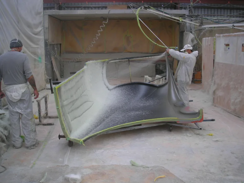 Fibreglass development team spraying fibreglass composite